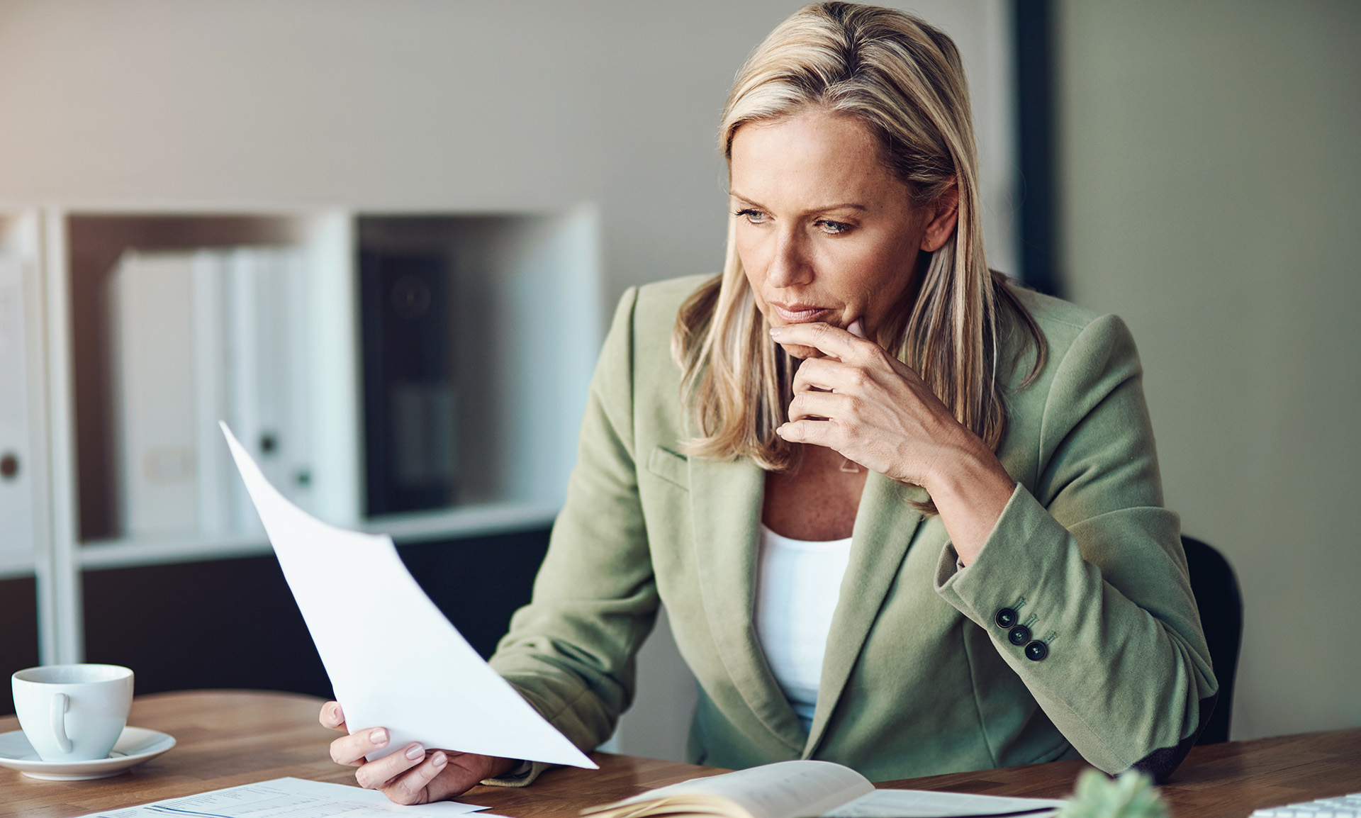 Office worker taking a thoughtful pause during their workday near a bright window
